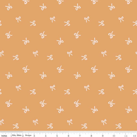 Image of Sweet Cotton Tales Twirls & Ties Apricot quilting cotton fabric by Cayla Naylor for Riley Blake Designs. Features bows on an orange background. Cute Little Fabric Shop