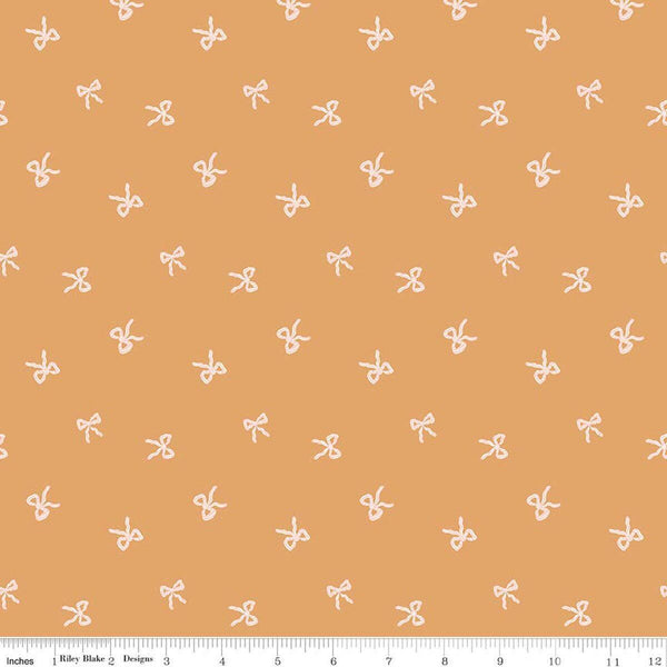Image of Sweet Cotton Tales Twirls & Ties Apricot quilting cotton fabric by Cayla Naylor for Riley Blake Designs. Features bows on an orange background. Cute Little Fabric Shop