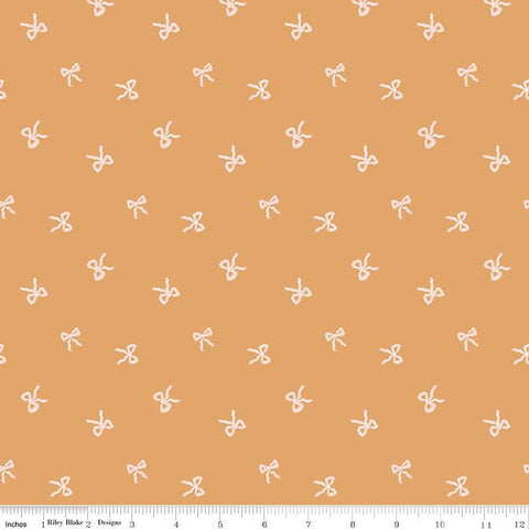 Image of Sweet Cotton Tales Twirls & Ties Apricot quilting cotton fabric by Cayla Naylor for Riley Blake Designs. Features bows on an orange background. Cute Little Fabric Shop