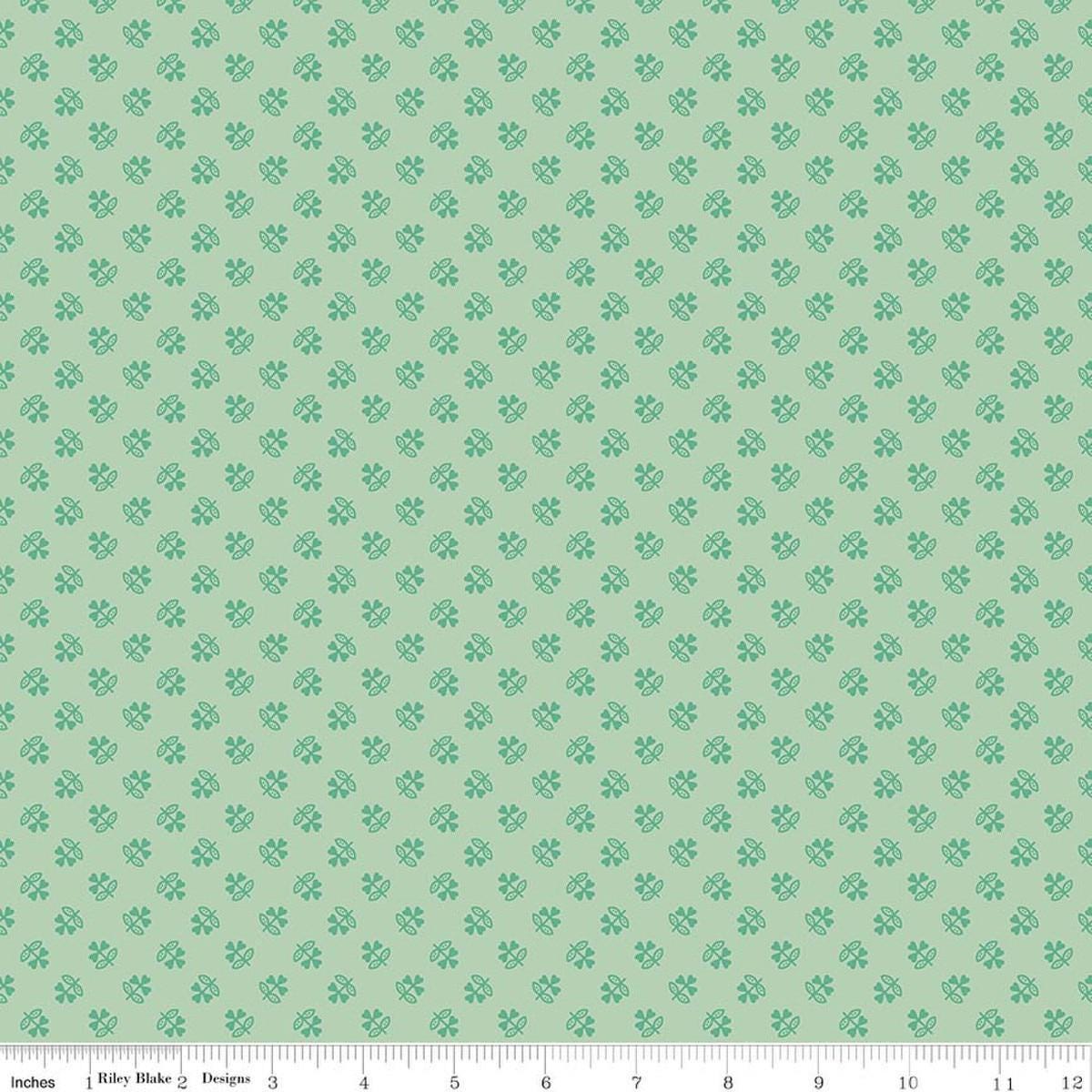 Image of Farmer's Daughter Clover Sage quilting cotton fabric by Lori Holt for Riley Blake Designs. Features plants on a green background. Cute Little Fabric Shop