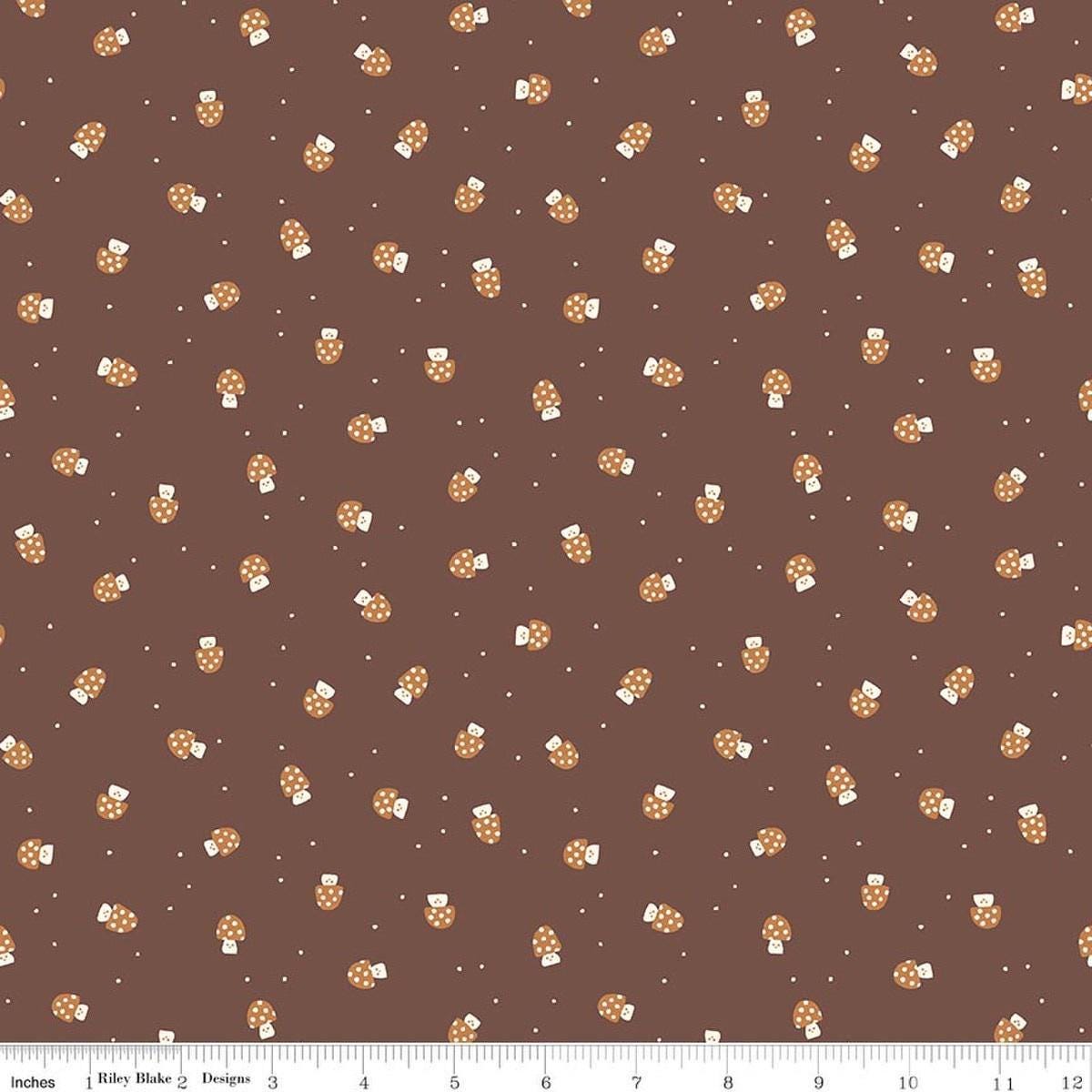 Image of Faraway Kingdom Mushroom Cheer Cocoa quilting cotton fabric by Natàlia Juan Abelló for Riley Blake Designs. Features mushrooms on a brown background. Cute Little Fabric Shop.
