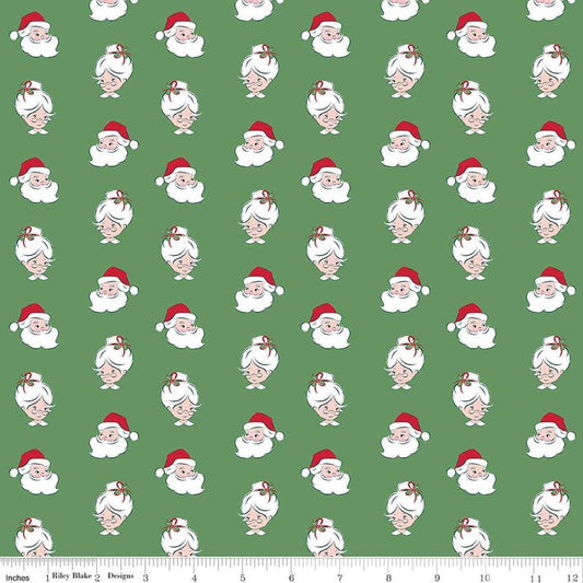 Image of Claus & Co. Santa Heads Green quilting cotton fabric by Melissa Mortenson for Riley Blake Designs. Features santa heads on a green background. Cute Little Fabric Shop.