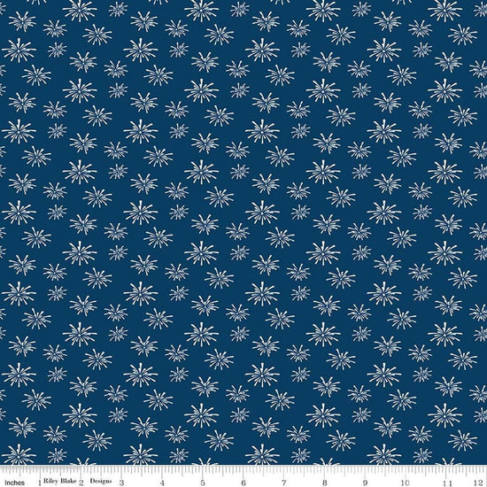 Image of Seasonal Basics Fireworks Denim quilting cotton fabric by Christopher Thompson for Riley Blake Designs. Features fireworks on a blue background. Cute Little Fabric Shop.