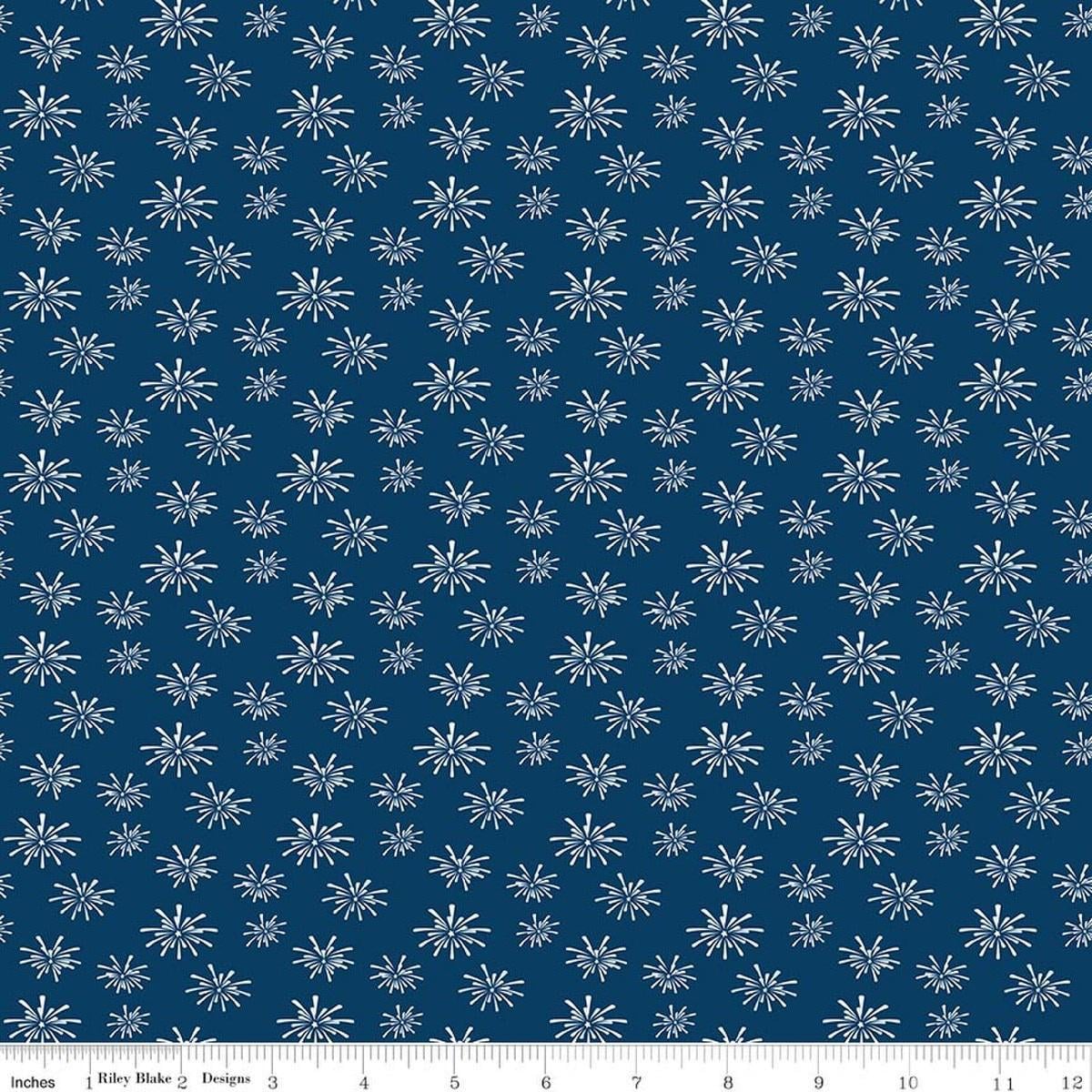 Image of Seasonal Basics Fireworks Denim quilting cotton fabric by Christopher Thompson for Riley Blake Designs. Features fireworks on a blue background. Cute Little Fabric Shop.