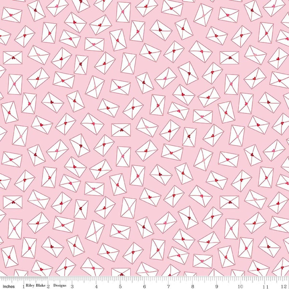 Image of Seasonal Basics Love Notes Pink quilting cotton fabric by Christopher Thompson for Riley Blake Designs. Features envelopes on a pink background. Cute Little Fabric Shop.
