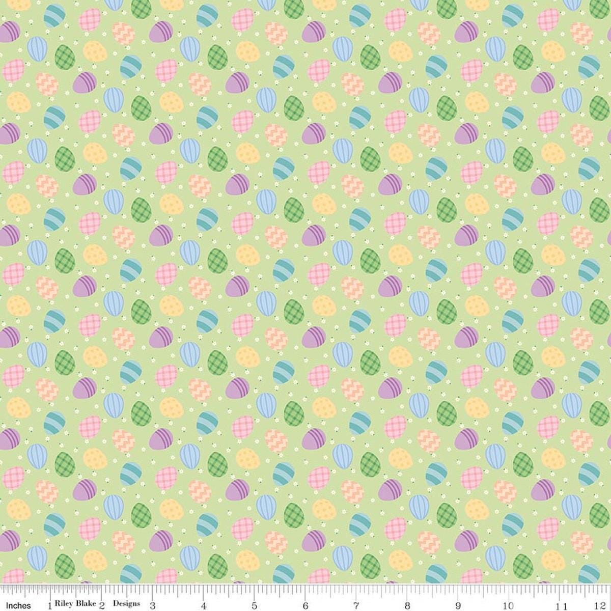 Image of Seasonal Basics Egg Toss Green quilting cotton fabric by Christopher Thompson for Riley Blake Designs. Features eggs on a green background. Cute Little Fabric Shop.
