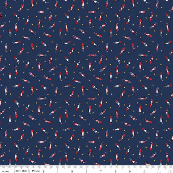 Image of Seasonal Basics Pop Boom Bang Navy quilting cotton fabric by Christopher Thompson for Riley Blake Designs. Features fireworks on a blue background. Cute Little Fabric Shop.