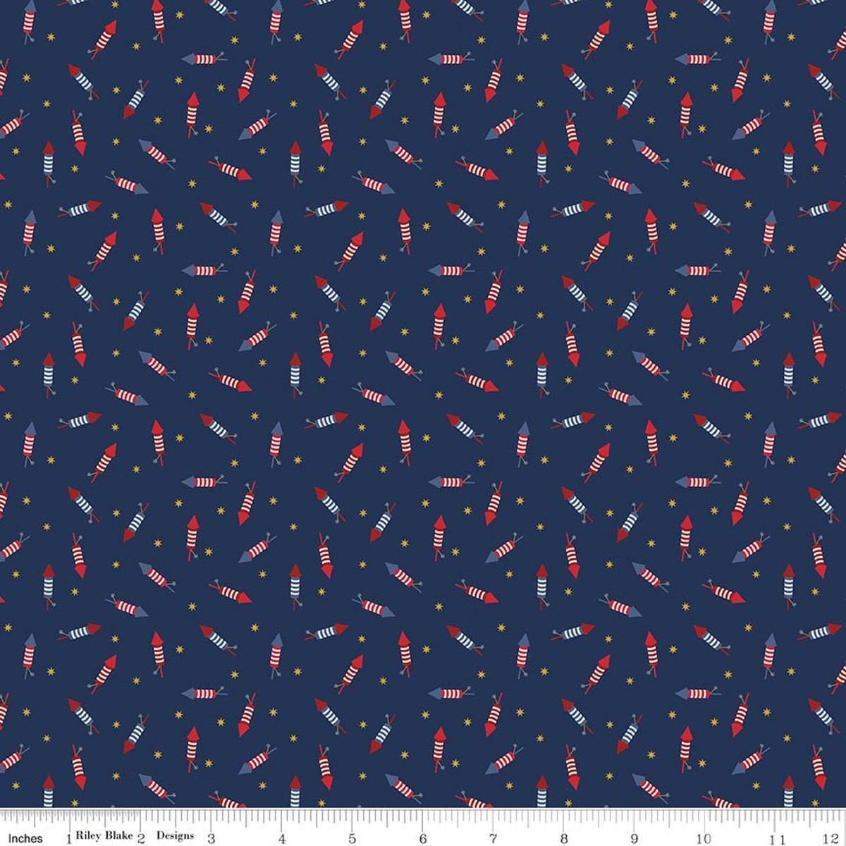 Image of Seasonal Basics Pop Boom Bang Navy quilting cotton fabric by Christopher Thompson for Riley Blake Designs. Features fireworks on a blue background. Cute Little Fabric Shop.