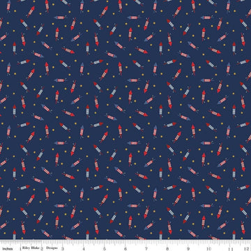 Image of Seasonal Basics Pop Boom Bang Navy quilting cotton fabric by Christopher Thompson for Riley Blake Designs. Features fireworks on a blue background. Cute Little Fabric Shop.