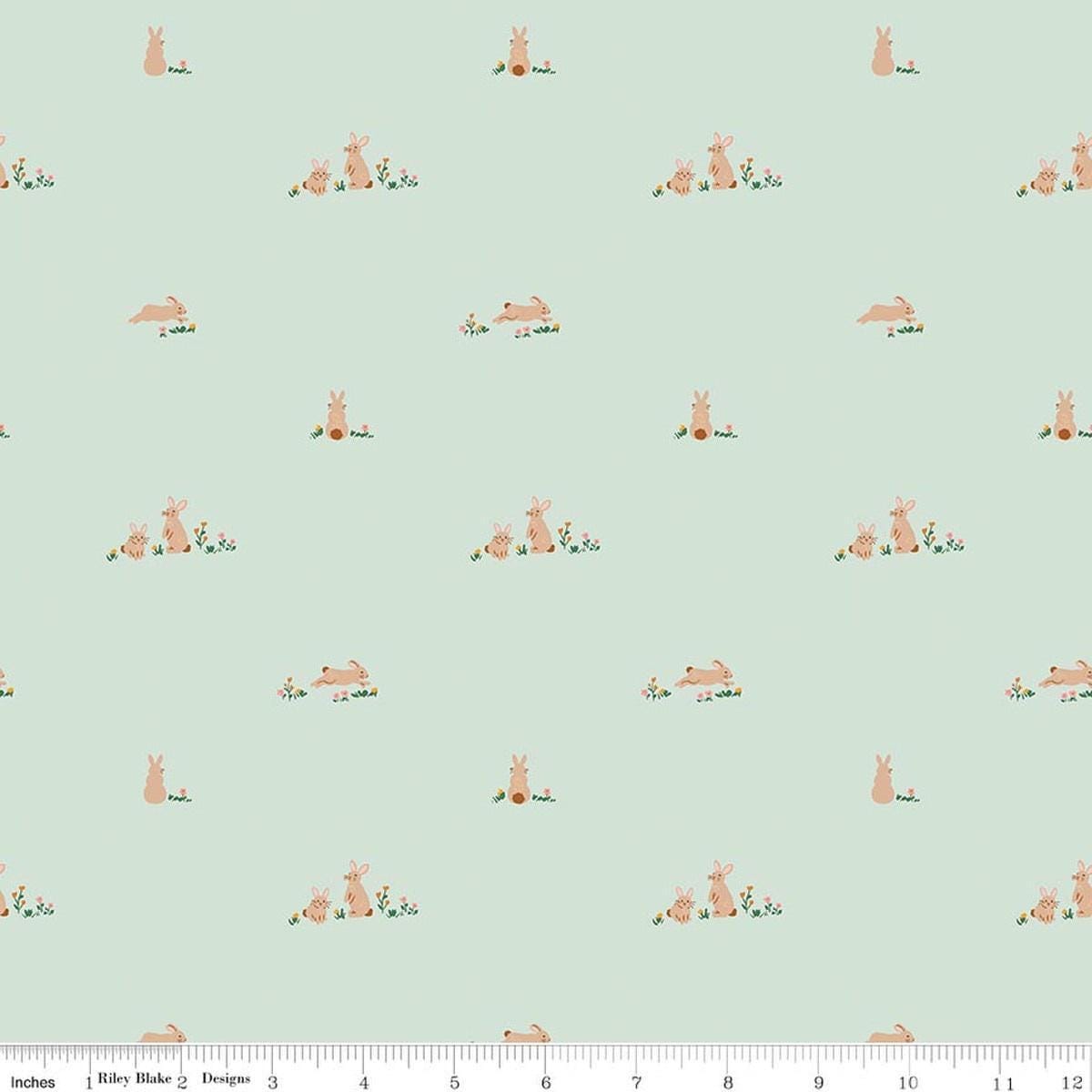 Image of Designer Flannel Sweet Cotton Tales Flopsy Fields Mint quilting cotton fabric by Little Forest Atelier for RIley Blake Designs. Features bunnies on a green background. Cute Little Fabric Shop.