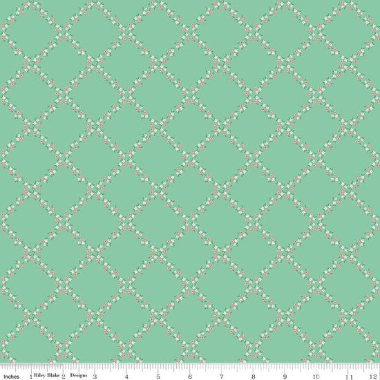 Image of Whimsical Woodland Lattice Green quilting cotton fabric by Tasha Noel for Riley Blake Designs. Features flowers on a green background. Cute Little Fabric Shop.