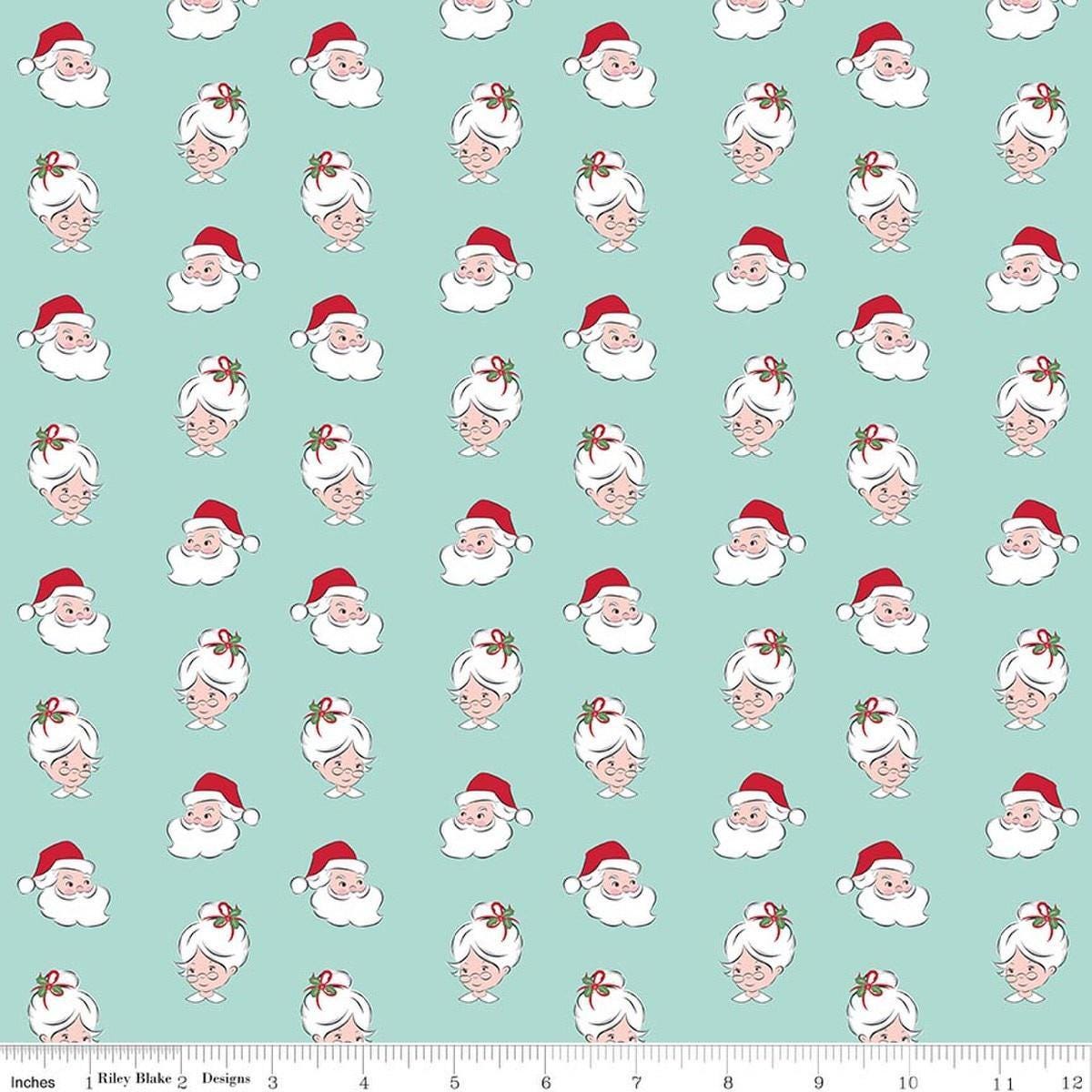Image of Claus & Co. Santa Heads Blue quilting cotton fabric by Melissa Mortenson for Riley Blake Designs. Features santa heads on a blue background. Cute Little Fabric Shop.