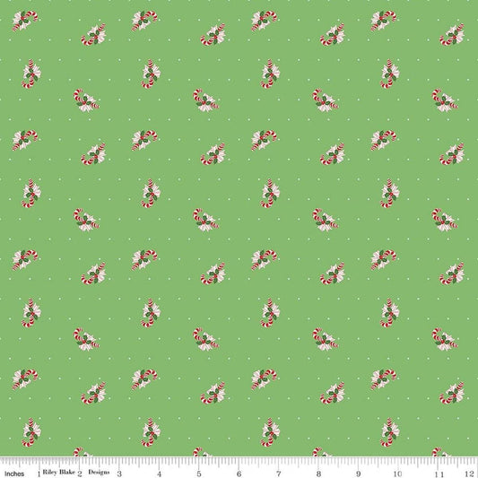 Image of Claus & Co. Candy Cane Toss Green quilting cotton fabric by Melissa Mortenson for Riley Blake Designs. Features candy canes on a green background. Cute Little Fabric Shop.