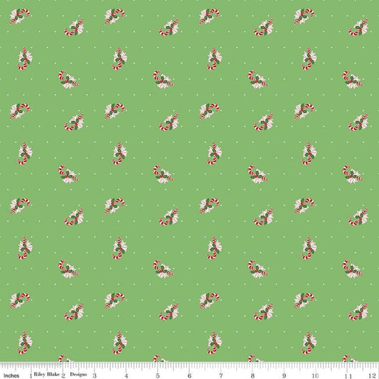 Image of Claus & Co. Candy Cane Toss Green quilting cotton fabric by Melissa Mortenson for Riley Blake Designs. Features candy canes on a green background. Cute Little Fabric Shop.