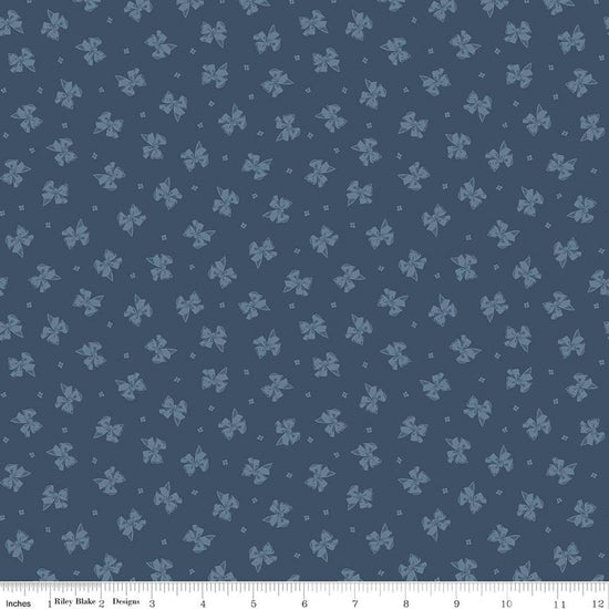 Image of Rosewood Petticoat Oxford quilting cotton fabric by Jessica Chertkow for Riley Blake Designs. Features bows on a blue background. Cute Little Fabric Shop.