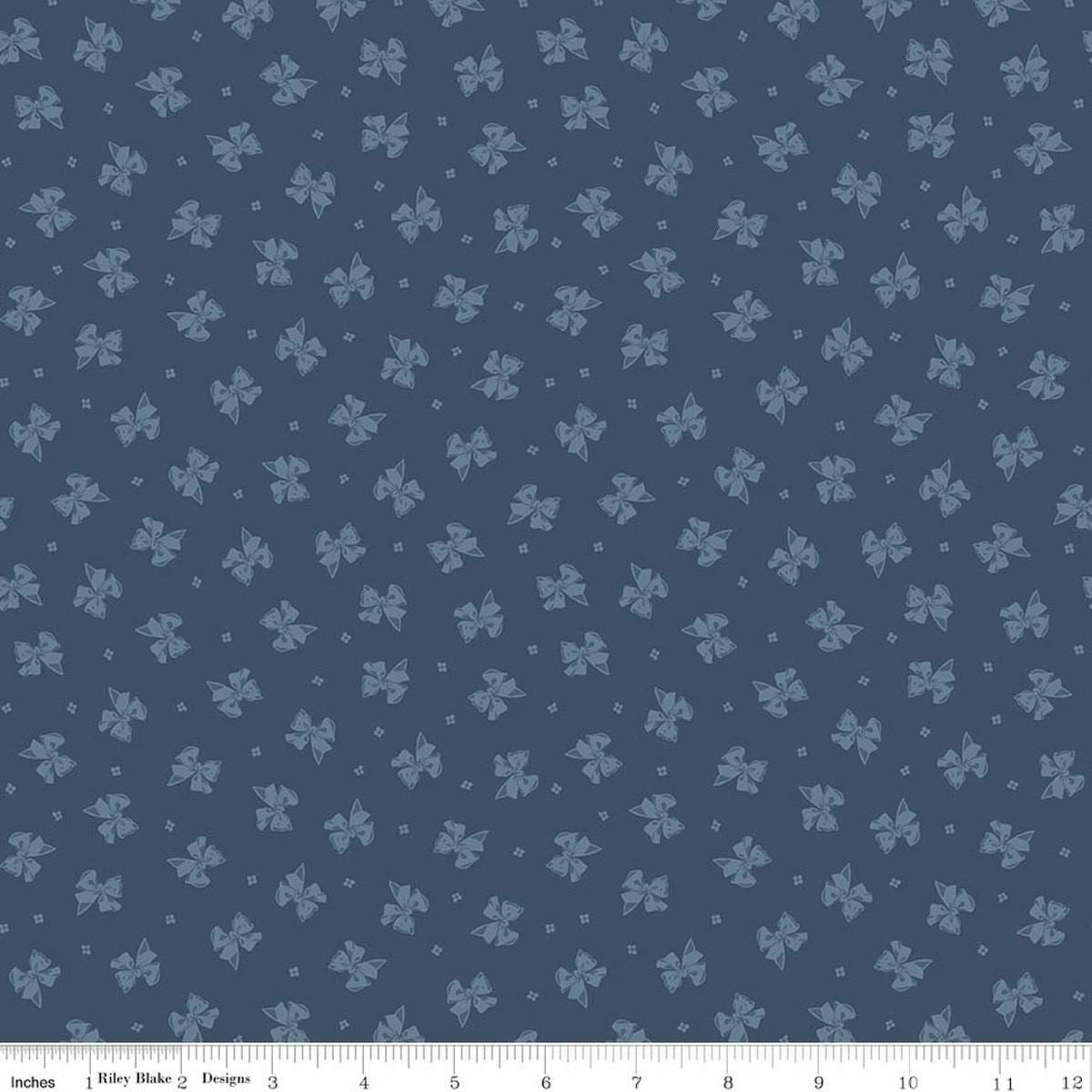 Image of Rosewood Petticoat Oxford quilting cotton fabric by Jessica Chertkow for Riley Blake Designs. Features bows on a blue background. Cute Little Fabric Shop.