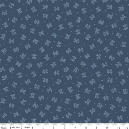 Image of Rosewood Petticoat Oxford quilting cotton fabric by Jessica Chertkow for Riley Blake Designs. Features bows on a blue background. Cute Little Fabric Shop.