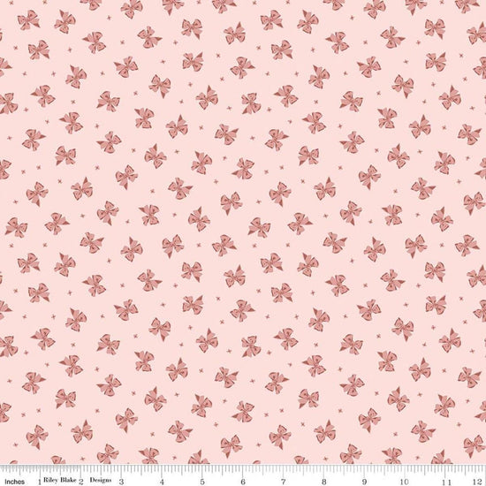 Image of Rosewood Petticoat Pink quilting cotton fabric by Jessica Chertkow for Riley Blake Designs. Features bows on a pink background. Cute Little Fabric Shop.