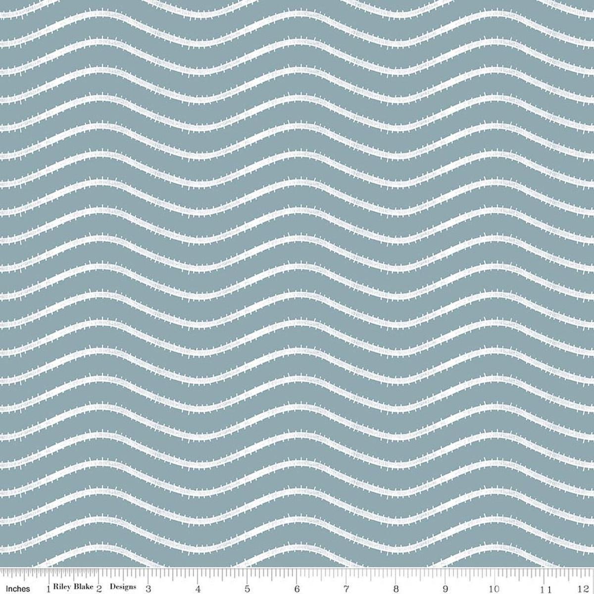 Image of Gingerbread Icing Stripes Blue quilting cotton fabric by J. Wecker Frisch for Riley Blake Designs. Features wavy stripes on a blue background. Cute Little Fabric Shop.