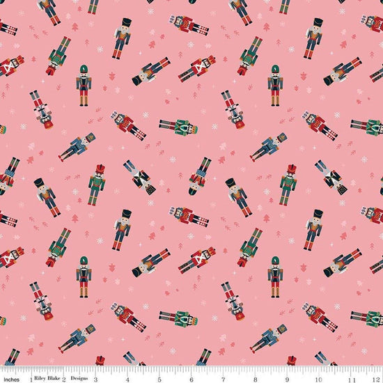 Image of Nutcracker Tradition Nutcracker Toss Sugar quilting cotton fabric by Jennifer Long for Riley Blake Designs. Features nutcrackers on a pink background. Cute Little Fabric Shop.