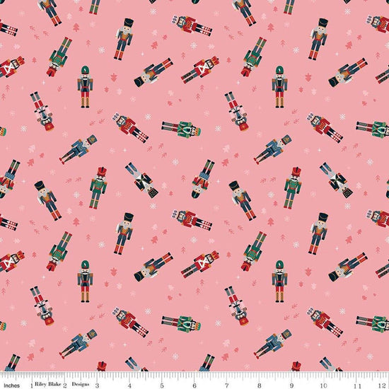 Image of Nutcracker Tradition Nutcracker Toss Sugar quilting cotton fabric by Jennifer Long for Riley Blake Designs. Features nutcrackers on a pink background. Cute Little Fabric Shop.