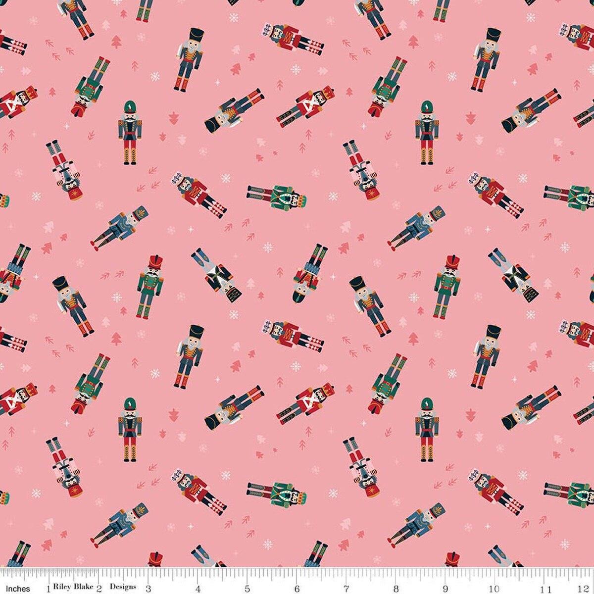 Image of Nutcracker Tradition Nutcracker Toss Sugar quilting cotton fabric by Jennifer Long for Riley Blake Designs. Features nutcrackers on a pink background. Cute Little Fabric Shop.