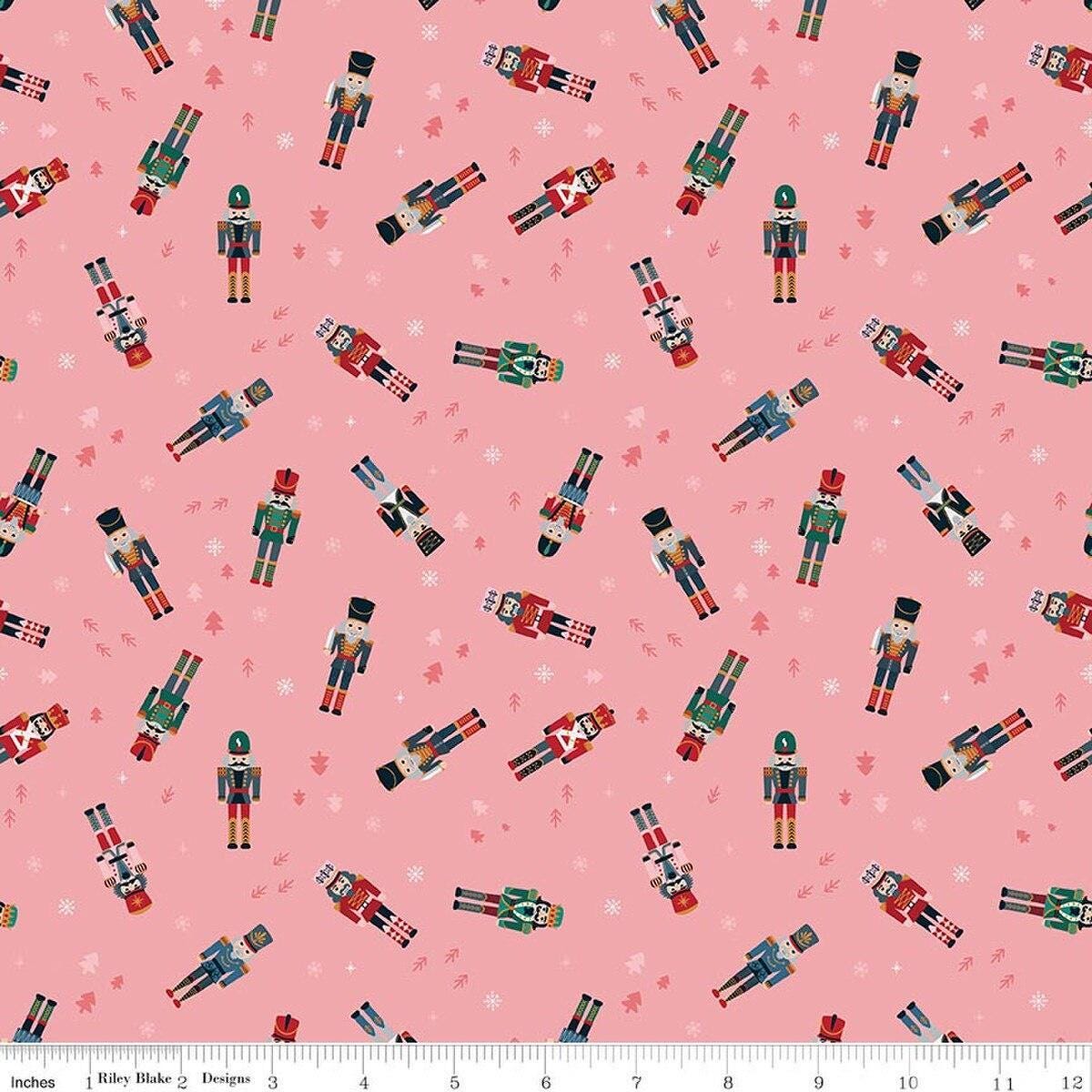 Image of Nutcracker Tradition Nutcracker Toss Sugar quilting cotton fabric by Jennifer Long for Riley Blake Designs. Features nutcrackers on a pink background. Cute Little Fabric Shop.