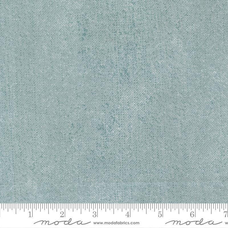 Image of Chilly White Out Storm quilting cotton fabric by Sweetwater for Moda Fabrics. Features printed texture on a blue background. Cute Little Fabric Shop.
