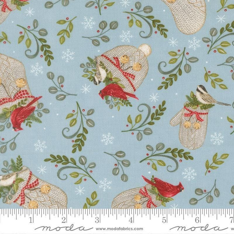 Image of When Snow Falls Winter Wear Winter Sky quilting cotton fabric by Deb Strain for Moda Fabrics. Features stockings, mittens, and leaves on a blue background. Cute Little Fabric Shop.