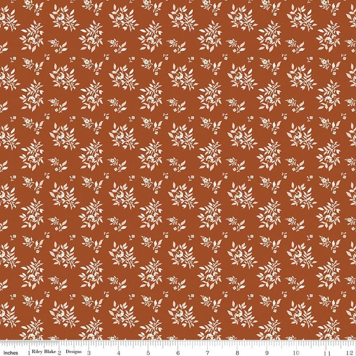 Image of Before the Blooms Juniper Rust quilting cotton fabric by Danelys Sidron for Riley Blake Designs. Features flowers on an orange background. Cute Little Fabric Shop.