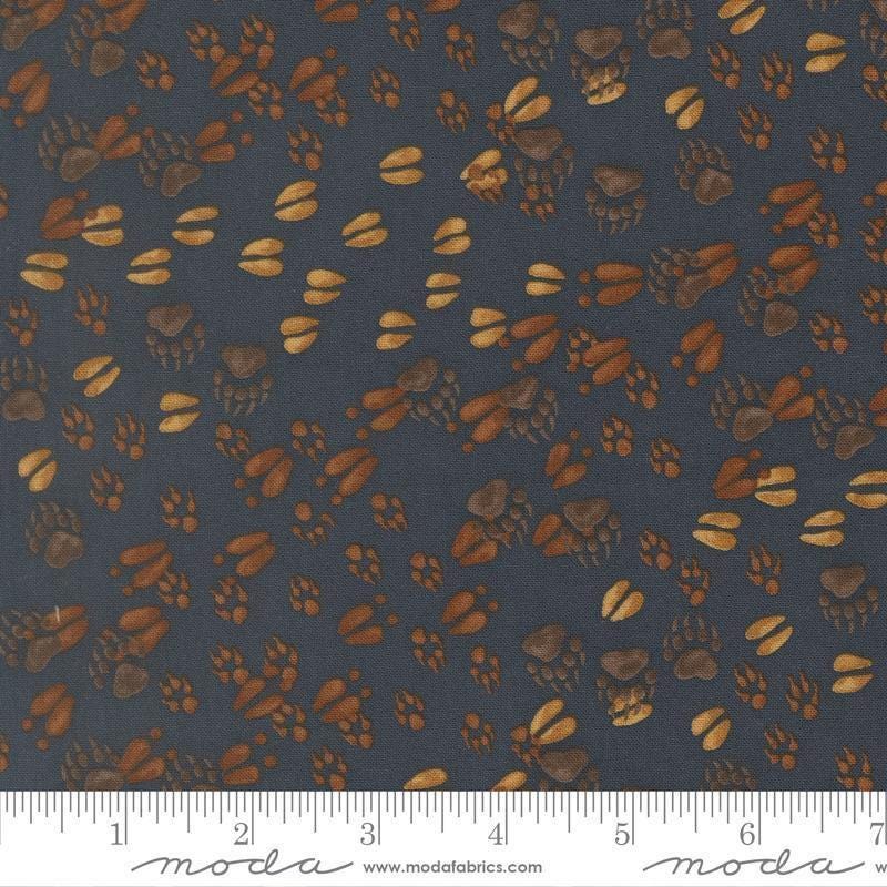 Image of Northwoods Lodge Animal Tracks Midnight quilting cotton fabric by Deb Strain for Moda Fabrics. Features animal footprints on a blue background. Cute Little Fabric Shop.