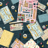 Image of Drawn to Create Artist's Journals Dark Teal quilting cotton fabric by Eulalia Mejia for QT Fabrics. Features art supplies on a blue background. Cute Little Fabric Shop.